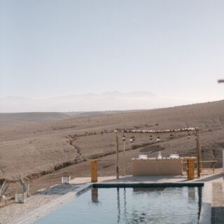 Camp pool and outdoor bar overlooking the hills of the Agafay desert
