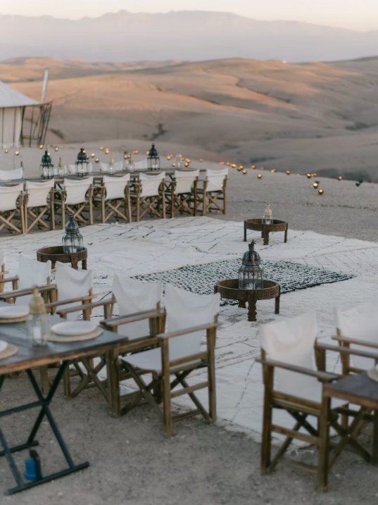 Agafay desert dinner setup moroccan rugs Outdoor dinner setup with Moroccan rugs and lanterns in the Agafay desert