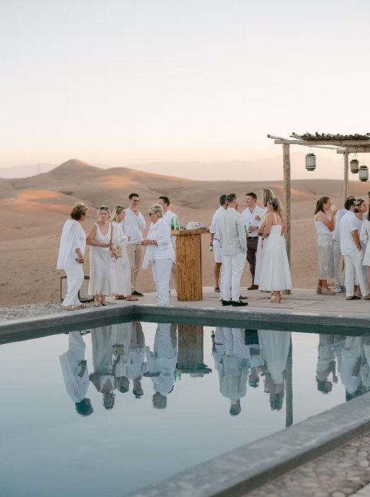 Agafay desert guests pool reflection Guests reflected in the pool of a luxury camp in the Agafay desert