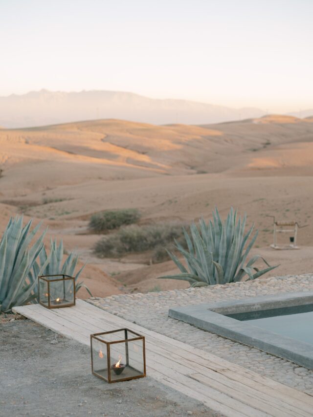 Lanterns along a wooden path beside a camp pool, Agafay desert view