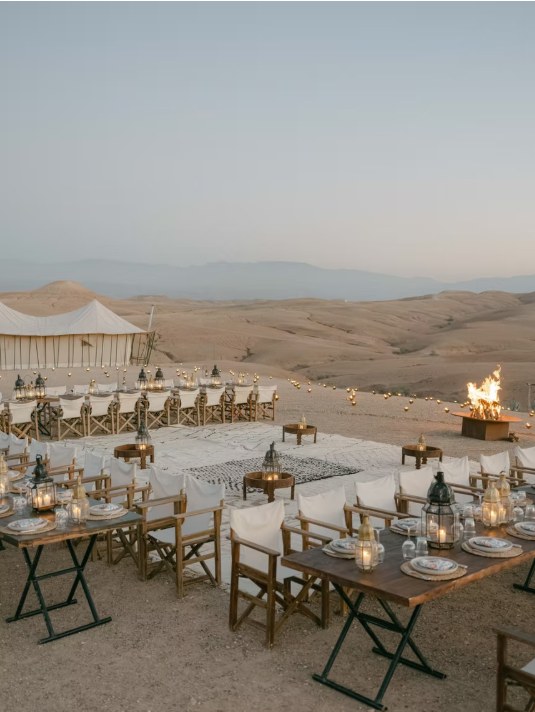 Wedding dinner tables and fire pit at a luxury camp in the Agafay desert
