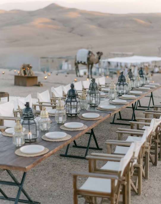 Agafay desert wedding long table lanterns Long wedding table with Moroccan lanterns facing the Agafay desert hills